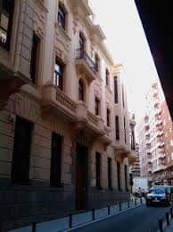Vista lateral del edificio histórico en la calle, mostrando su arquitectura clásica