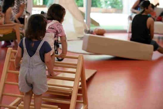 Niños jugando con estructuras de madera en el espacio abierto