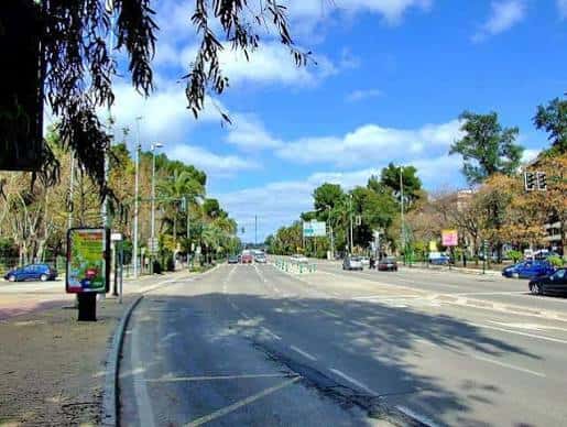 Vista de la Avenida del Conde de Vallellano con árboles y tráfico