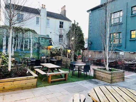 Terraza vacía del Signalman con mobiliario moderno y decoración de árboles jóvenes