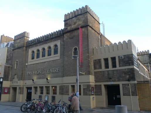 Fachada frontal del Pavilion Theatre con bicicletas aparcadas y letrero rojo vertical