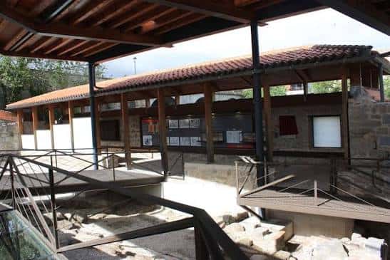 Interior del museo arqueológico con techumbre de madera y exposiciones