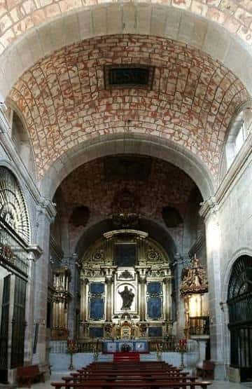 Interior de la iglesia con altar barroco y bóveda de ladrillo