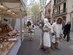Stand de comercio local en la Mostra de Comerç al carrer Vallespir con participantes disfrazados