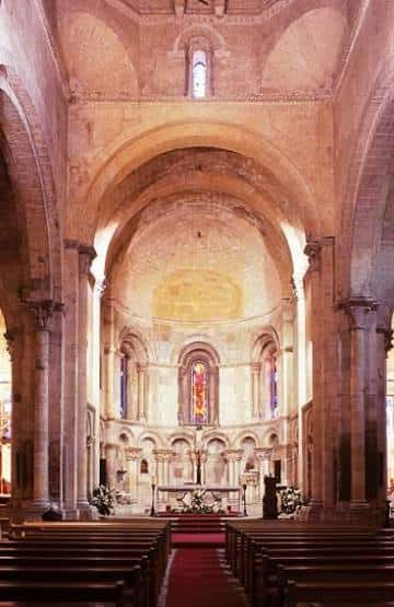 Interior de la iglesia mostrando el altar mayor y las bancas de madera