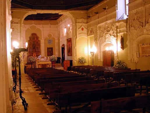 Vista del interior de la capilla con bancos y decoración para evento