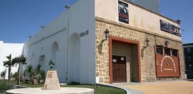 Fachada de la Peña Flamenca La Perla con escultura frente al mar