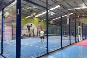 Jugadores en acción dentro de una pista de pádel cubierta