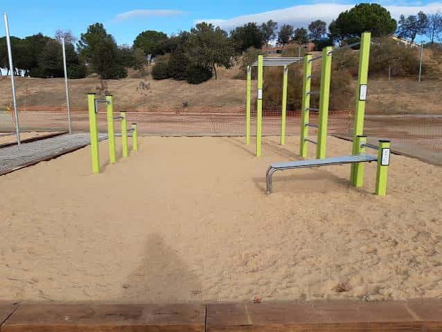 Área de entrenamiento al aire libre con equipo deportivo en el suelo de arena