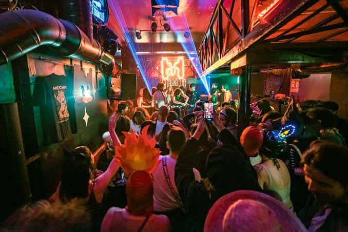 Escenario interior del club con banda en vivo y ambiente festivo