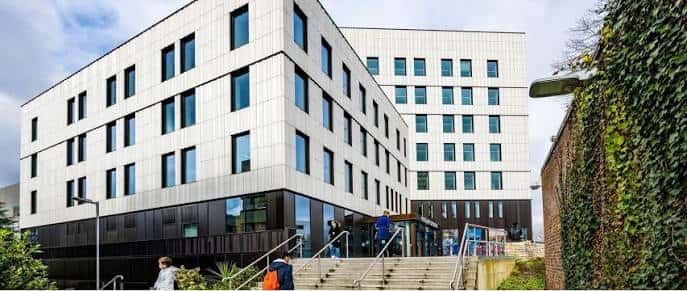 Vista exterior del edificio moderno de la Escuela de Química e Ingeniería Química con fachada blanca y escaleras principales