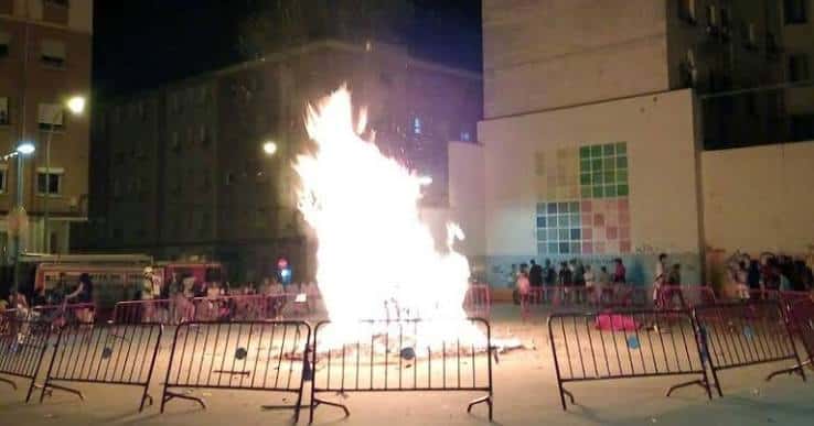 Celebración nocturna en el barrio Madre de Dios con hoguera y público