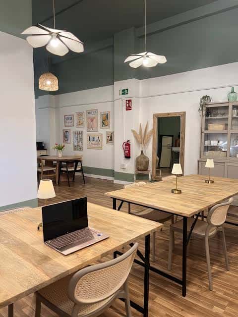 Área de coworking en Mara Espacio Creativo con escritorios y lámparas colgantes