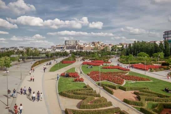 Jardines formales y senderos peatonales en Madrid Río con visitantes disfrutando del espacio