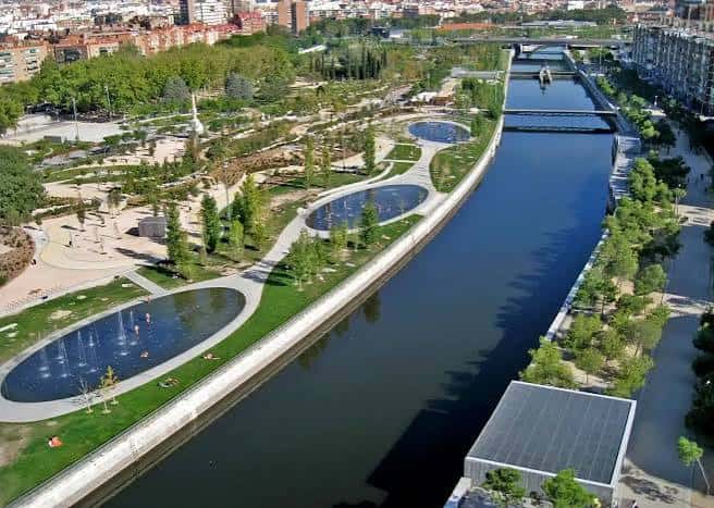 Vista aérea del parque lineal junto al río Manzanares con zonas verdes y fuentes