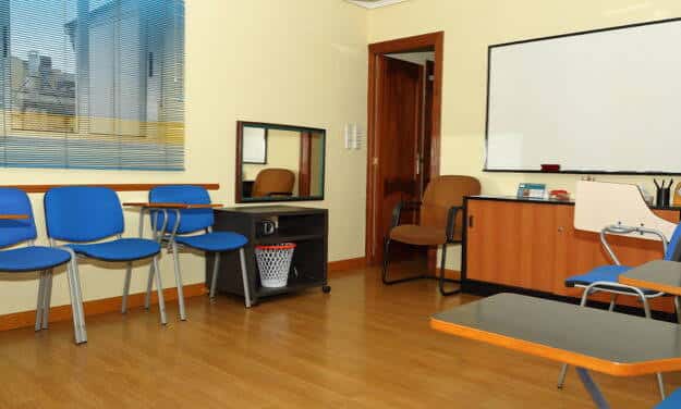 Sala de terapia con mobiliario funcional y pizarra blanca