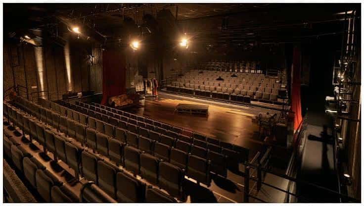 Vista panorámica del interior del auditorio mostrando el escenario y las butacas vacías