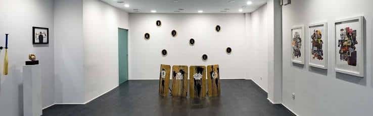 Sala principal de la galería con obras de arte expuestas en paredes blancas