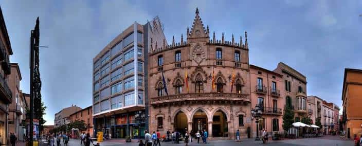 Panorámica del Raval de Montserrat con el edificio gótico central y gente caminando en la plaza