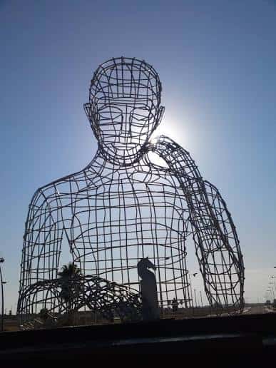 Vista de la escultura El Pensador en Dos Hermanas con el sol brillando a través de su estructura metálica