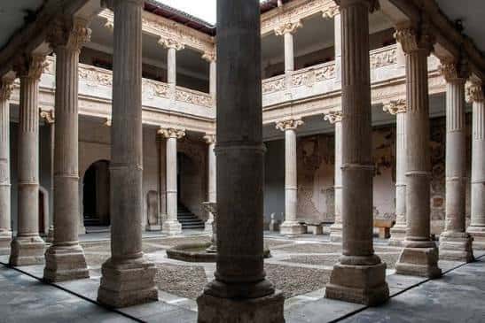 Claustro renacentista con columnas de piedra y galerías superiores