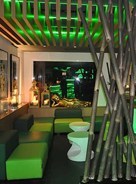 Sala de estar con sofás verdes y decoración de bambú