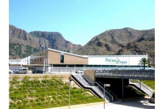 Vista exterior del Palacio del Agua con fachada moderna y montañas al fondo