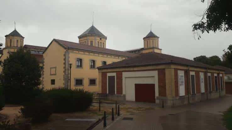 Vista exterior del edificio La Cárcel Centro de Creación con torres y fachada amarilla