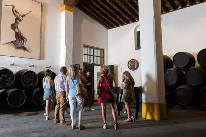 Grupo de personas visitando las barricas en el interior de la bodega