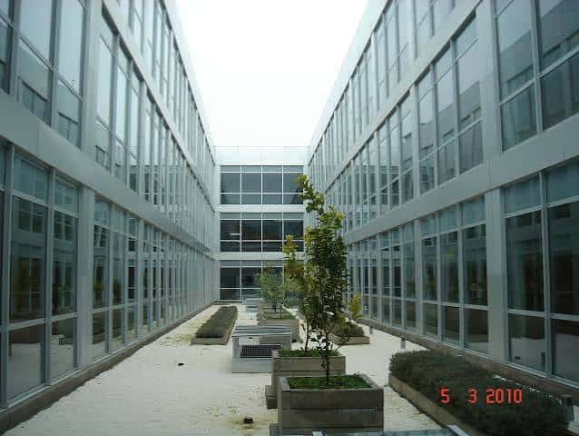 Patio interior del edificio con diseño arquitectónico moderno y vegetación
