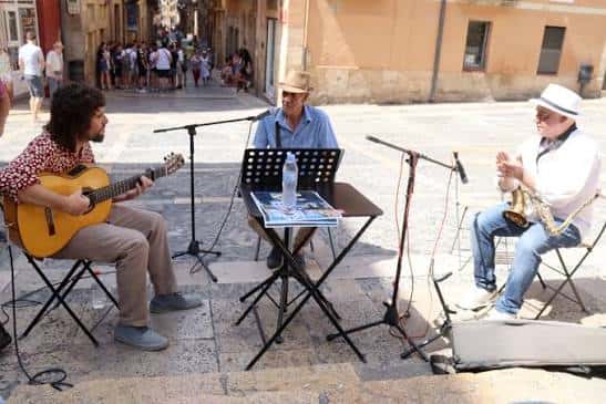 Músicos tocando rumba catalana en la plaza con instrumentos típicos