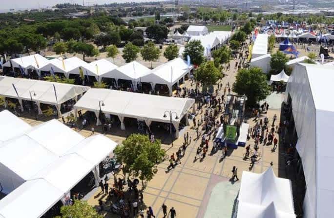 Vista aérea del recinto ferial con múltiples carpas blancas y público transitando