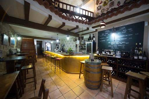 Interior acogedor del Pub Lume con barra iluminada y decoración rústica