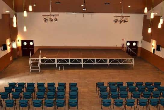 Auditorio del centro cívico con escenario y sillas dispuestas para eventos