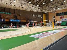 Partido de voleibol en el Pabellón Polideportivo Feria, mostrando la cancha y gradas