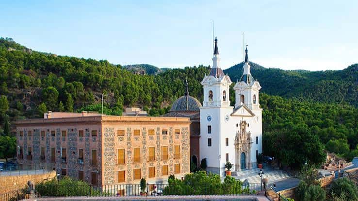 Vista panorámica del Santuario de la Fuensanta con el edificio anexo y las colinas verdes al fondo