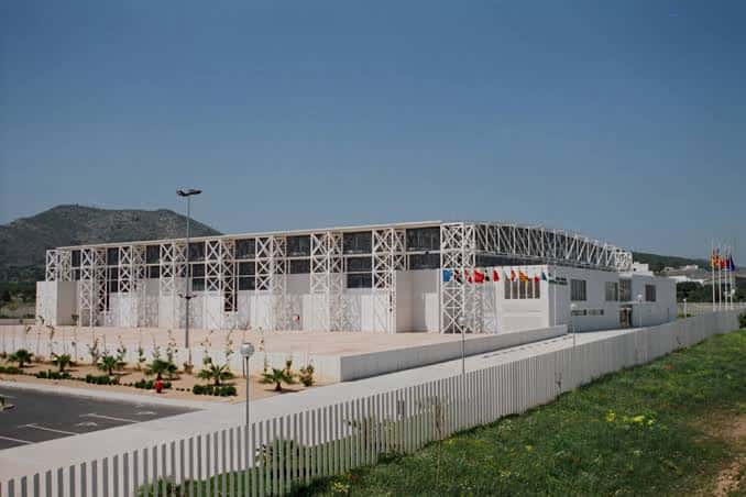 Edificio del recinto ferial desde una perspectiva amplia con montañas al fondo