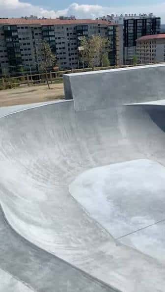 Detalle de la estructura de hormigón del skatepark con edificios residenciales al fondo