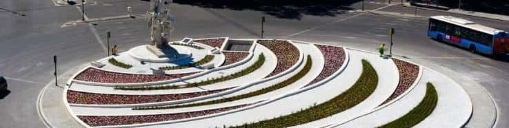 Plaza circular frente al centro con escalinata en espiral y monumento central, ideal para eventos al aire libre