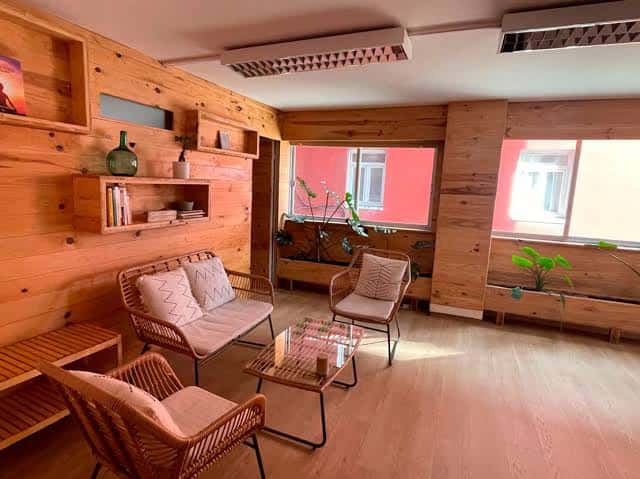 Sala de espera acogedora con paredes de madera y mobiliario rústico