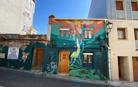 Fachada de edificio con mural colorido en el Barrio de Canido