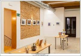Vista interior de la sala de exposiciones con paredes de ladrillo y mobiliario para eventos