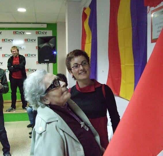 Interior de la sala durante un evento cultural con banderas catalanas y decoración temática
