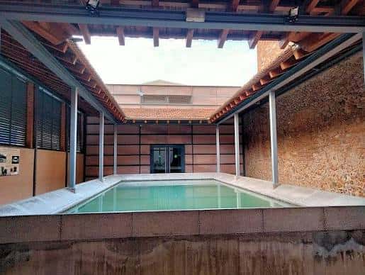 Interior del patio central con piscina y estructura de madera y metal