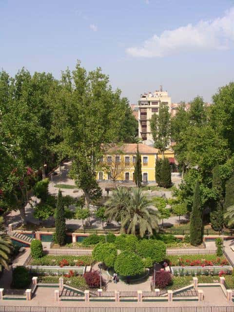 Vista panorámica del Jardín de la Pólvora con el edificio amarillo y palmeras