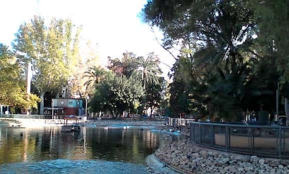 Lago en el Jardín de la Pólvora con árboles frondosos al atardecer