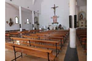 Interior de la iglesia con bancos y altar