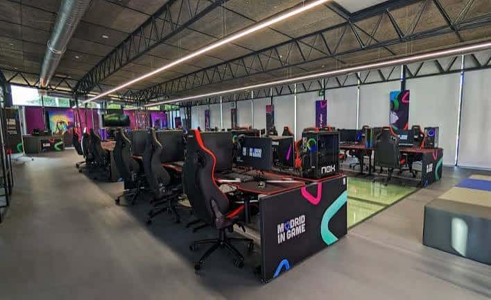 Interior del campus con estaciones de juego profesionales y equipamiento esports