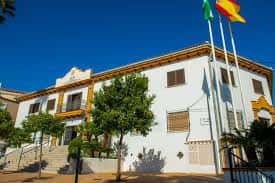 Exterior del edificio con banderas española y andaluza ondeando al viento