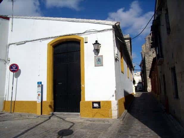 Fachada exterior del Centro Cultural Don Antonio Chacón con puerta arqueada y detalles en amarillo